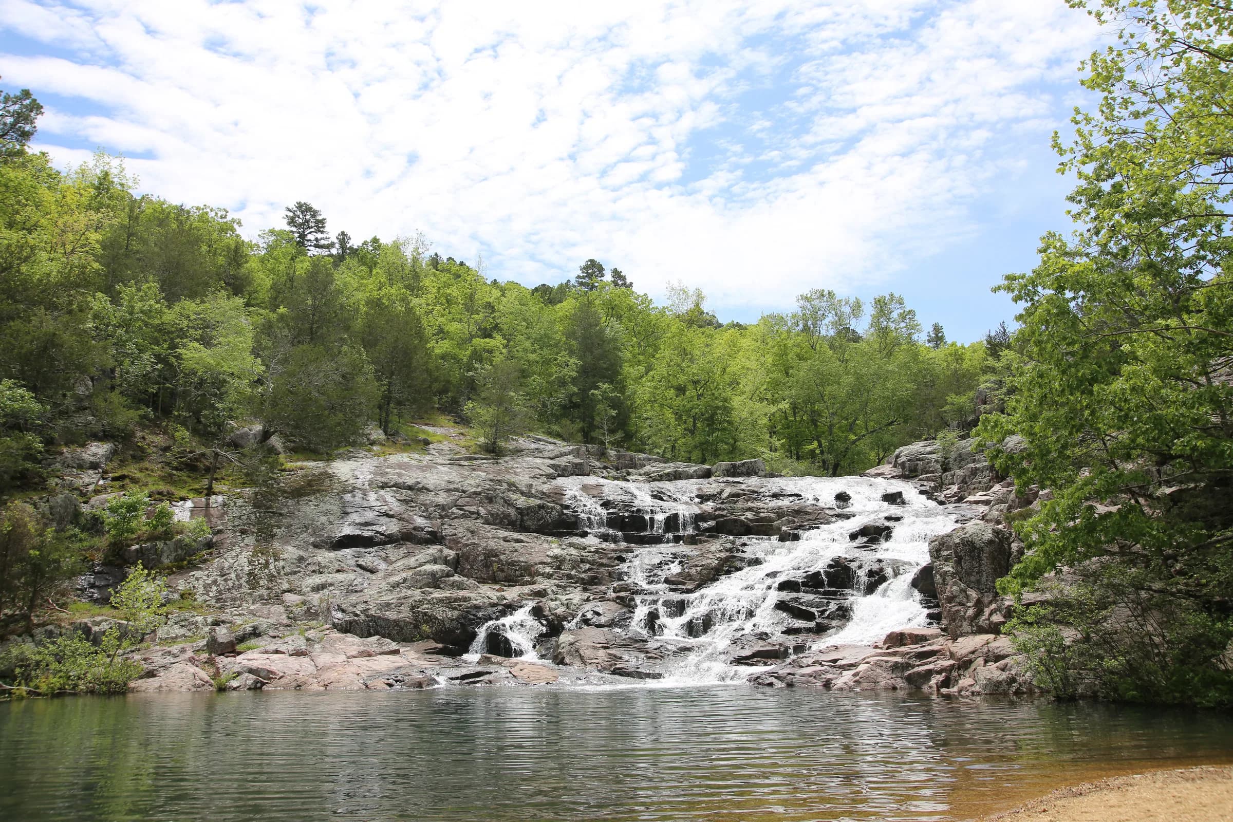 Water spilling over reddish rhyolite into the pool at Rocky Falls